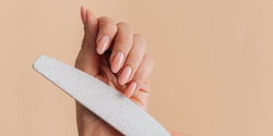 Lima manualmente una uña con forma de almendra con una lima blanca, guía de formas de uñas